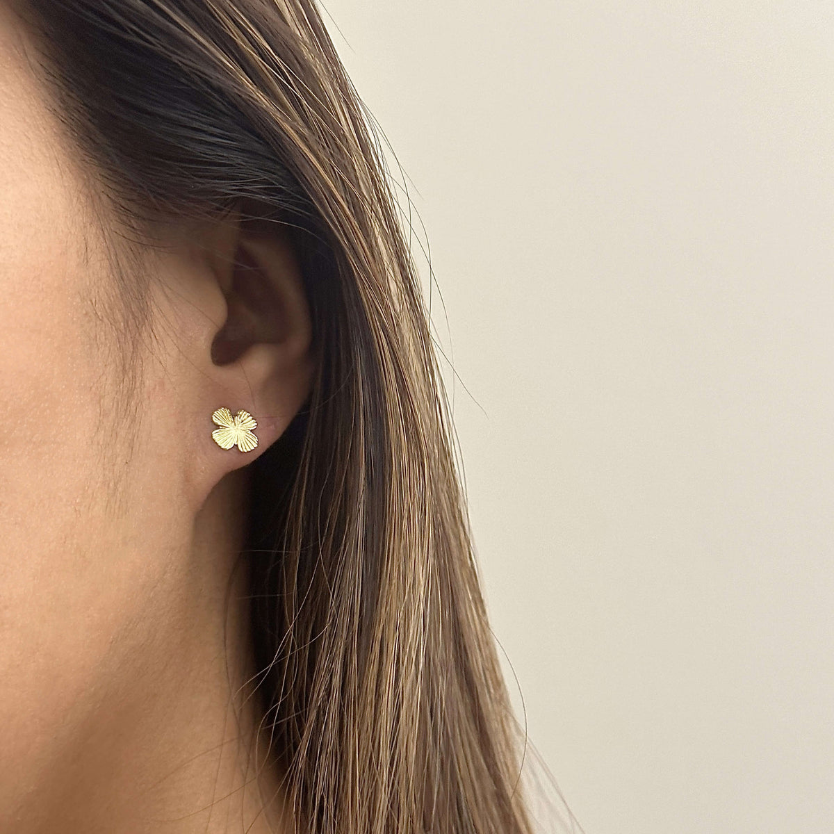 Close-up view of the Clover earrings showing intricate detailing on the leaves, Model wearing Clover earrings, showcasing their elegant and nature-inspired look